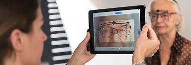 l'opticien à domicile analyse la vision d'une patiente à l'aide d'un outil numérique adapté