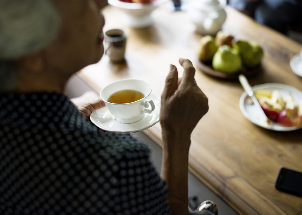 Personne âgée assise à table le temps d'une pause thé