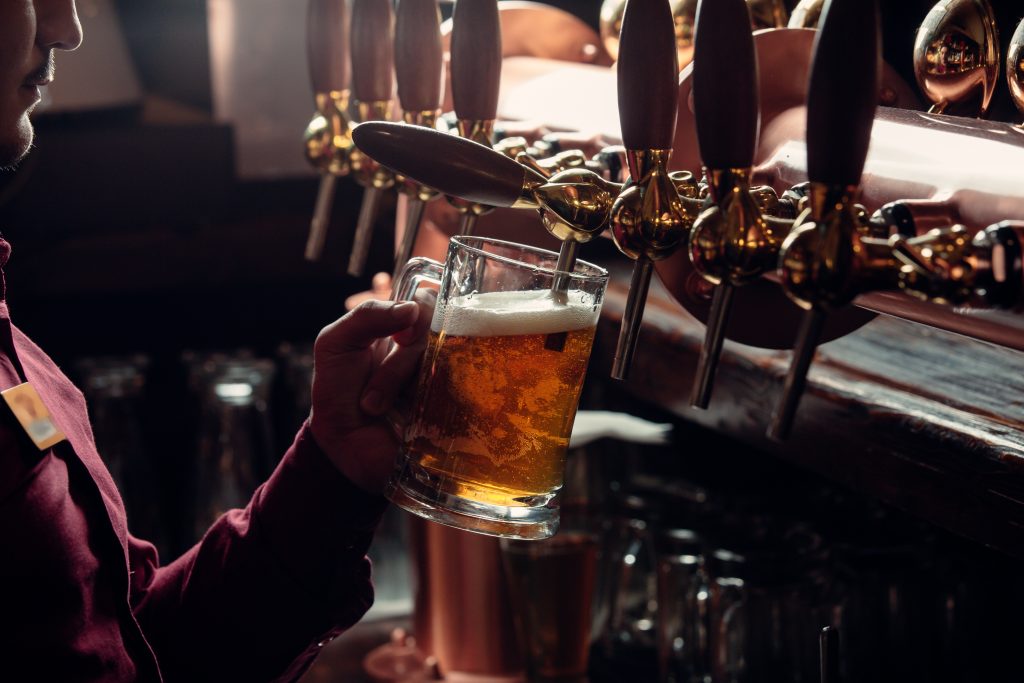 Serveur d'un bar remplissant un verre de bière 
