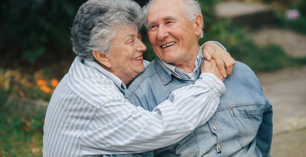 Una pareja de ancianos en un parque. Abuelos abrazándose. 